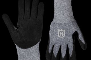 Vorderansicht von zwei Husqvarna Arbeitshandschuhen mit dem Logo auf einem Handschuh.