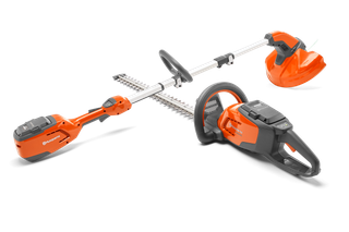 Side view of a Husqvarna hedge trimmer and grass trimmer, showcasing their battery compartments.