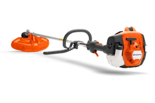 Side view of a Husqvarna brush cutter with ergonomic handle and cutting blade.