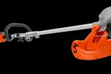 Side view of a Husqvarna string trimmer with ergonomic handle and protective guard.
