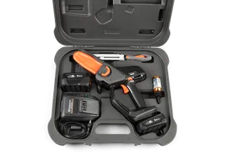 Bovenaanzicht van een Husqvarna-snoeiset in een koffer, inclusief batterijen, oplader en accessoires.
