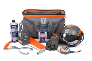 Front view of a Husqvarna tool kit including a helmet, gloves, fuel, and various accessories.