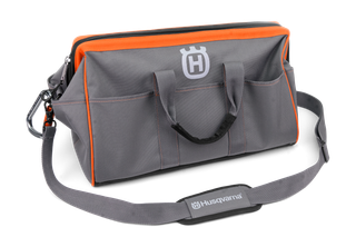 Front view of a Husqvarna tool bag with multiple pockets and a shoulder strap.