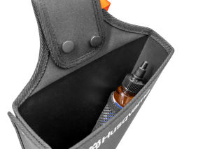 Widok z góry na saszetkę na akcesoria Husqvarna zawierającą małą butelkę.