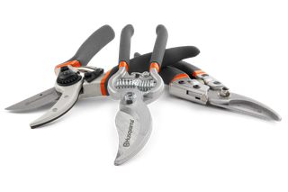 Front view of various Husqvarna gardening shears arranged on a white surface.