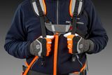 Людина в пасовій підвісці та рукавицях Husqvarna, з акцентом на груди та плечі.