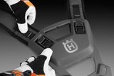 Nærbillede af en person, der justerer en sele med et synligt Husqvarna-logo.