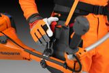 Nærbillede af en person i arbejdsudstyr, der justerer et Husqvarna-produktsele.