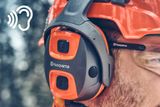 Nahaufnahme einer Person, die Husqvarna Gehörschutzausrüstung trägt, mit einem Soundsymbol-Overlay.
