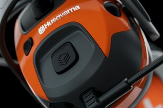 Zbliżenie produktu Husqvarna prezentującego jego konstrukcję i przyciski sterujące.