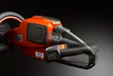 Side view of a Husqvarna chainsaw handle with control buttons.