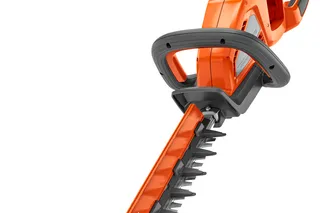 Side view of a Husqvarna hedge trimmer with a long cutting blade.
