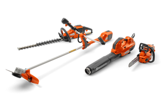Front view of a set of Husqvarna gardening tools including a hedge trimmer, leaf blower, chainsaw, and grass trimmer.
