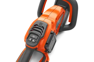 Close-up view of a Husqvarna chainsaw handle and control panel.