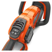 Close-up view of a Husqvarna chainsaw handle and control panel.