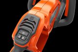 Close-up view of a Husqvarna product handle with control buttons.