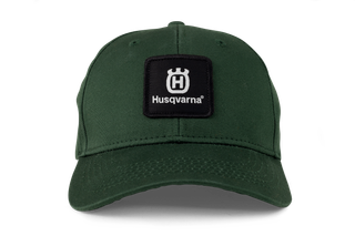 Vooraanzicht van een pet met Husqvarna-logo en logopatch.