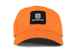 Vooraanzicht van een oranje pet met Husqvarna-branding.