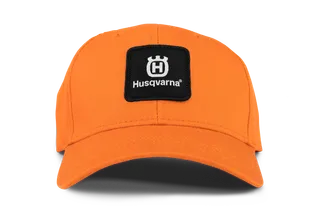 Vooraanzicht van een oranje pet met Husqvarna-branding.