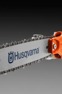 Vista lateral de uma podadora com vara Husqvarna com corrente e lâmina visíveis.