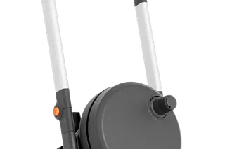 Side view of a Husqvarna pressure washer with wheels and a hose reel.