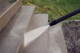 A pressure washer cleaning outdoor stone steps.