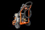 Rear view of a portable pressure washer with hose coiled on the frame.