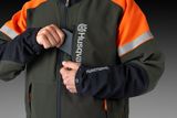 En person som bär en Husqvarna-jacka och en ficka med Husqvarna-logotypen.
