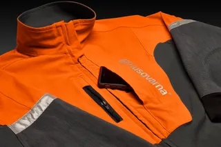 Front view of a Husqvarna work jacket with a smartphone in the chest pocket.