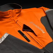 Front view of a Husqvarna work jacket with a smartphone in the chest pocket.