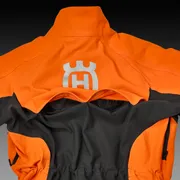 Rear view of a Husqvarna work jacket with ventilation features.