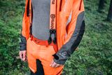 Особа в робочому екіпіруванні Husqvarna в лісі.