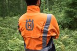 Людина в лісі обличчям у робочому одязі Husqvarna.