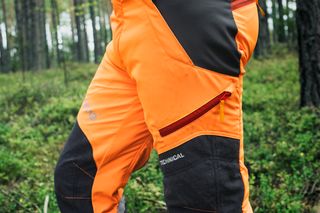 Person facing away wearing Husqvarna chainsaw trousers.
