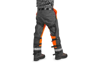 Rear view of a person wearing work trousers with reflective straps and sturdy boots.