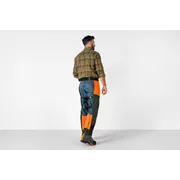 Osoba otočená smerom v pracovných nohaviciach so zosilnenými nášivkami.