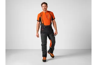 En person som har på seg arbeidsutstyr, inkludert bukser med bukseseler, går forover.