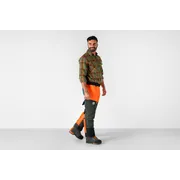 Osoba otočená odvrátenou stranou v nohaviciach Husqvarna s motorovou pílou.