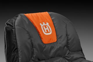 Close-up of a Husqvarna branded padded seat with a prominent logo.