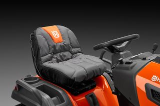 Close-up of a ride-on mower seat with ergonomic design and control panel.