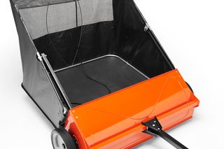 Side view of a lawn sweeper with a collection bag and wheels.