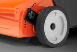 Close-up view of a lawn mower wheel and brush attachment.