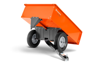 Vue latérale d’un chariot à benne basculante Husqvarna avec roues robustes et attache d’attelage.