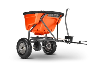 Zijaanzicht van een tuinstrooier met grote wielen en een stevig frame.