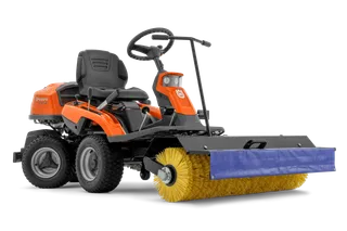 Vue latérale d’une balayeuse autoportée Husqvarna avec une brosse rotative montée à l’avant.