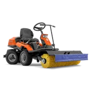 Vue latérale d’une balayeuse autoportée Husqvarna avec une brosse rotative montée à l’avant.