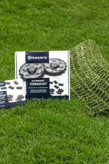 Husqvarna Automoweri maastikukomplekt ja tarvikud kuvatakse muruplatsil.