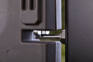 Close-up view of a mechanical component with a bolt and a textured surface.