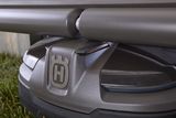 Close-up view of a Husqvarna robotic lawn mower under a shelter.