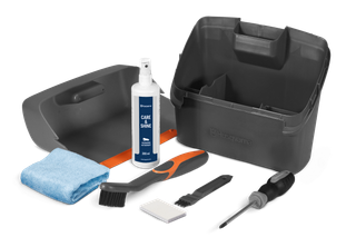 Top view of a Husqvarna cleaning kit including a spray bottle, cloth, brushes, and a screwdriver.